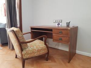 einen Holzschreibtisch mit einem Stuhl neben einem Holzschreibtisch in der Unterkunft Jasmine Central Apartment in Sofia