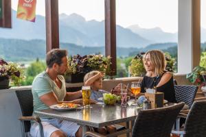 a family sitting at a table in a restaurant at EuroParcs Pressegger See in Hermagor