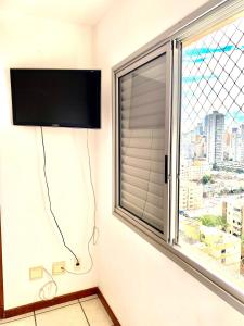 een kamer met een raam en een flatscreen-tv bij Apartamento de 3 quartos 3 banheiros no melhor do bueno in Goiânia