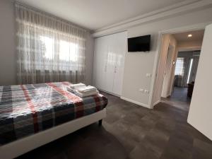 1 dormitorio con 1 cama y TV en la pared en Ferrarin Thiene, en Thiene