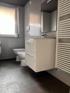 bagno bianco con servizi igienici e finestra di Ferrarin Thiene a Thiene