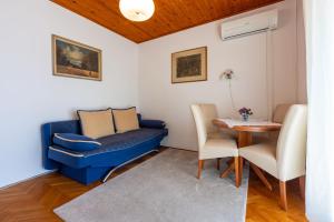 a living room with a blue couch and a table at Apartments Hinic in Selce