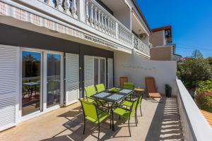 a patio with a table and chairs on a balcony at Apartments PERA in Selce