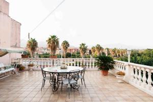 a patio with a table and chairs on a balcony at Terrazza Angela in Fiumefreddo di Sicilia