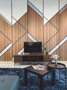 a living room with a tv and a table at Brand New Cozy Home Desaru Coast Near to SKS waterpark hard rock in Bandar Penawar