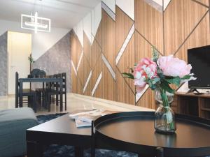 a vase of flowers on a table in a living room at Brand New Cozy Home Desaru Coast Near to SKS waterpark hard rock in Bandar Penawar