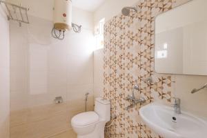 a bathroom with a toilet and a sink at SPLENDID SHUBHAM SERVICED APARTMENTS in Bengaluru +36 photos