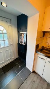 a small kitchen with a white door and a window at LA VILLA DEKO - Studio avec parking proche Université et Hôpital in Beuvry