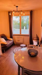 a living room with a table and a window at LA VILLA DEKO - Studio avec parking proche Université et Hôpital in Beuvry