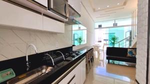 a kitchen with a sink and a counter top at Apartamento a 400 metros da praia de taparapuan in Porto Seguro