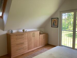 a bedroom with a wooden dresser and a window at Vulkanland Stoeckel - Feldbach in Feldbach