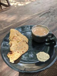 a plate with a tortilla and a cup of coffee at Cosmos @ Greenspace in Siolim