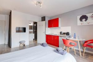 1 dormitorio con armarios rojos y cocina con mesa en Annecy Studio balcony close to old town, en Annecy