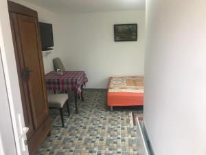 um quarto com uma mesa e uma cama e uma mesa e cadeira em Salaš Vujić em Bečej