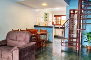 een woonkamer met een bank en een tafel en een keuken bij 100mts DA PRAIA com Churrasqueira, Piscina e Wi-Fi in Caraguatatuba