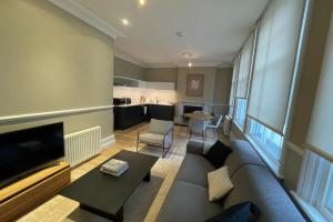a living room with a couch and a tv at Central 1 Bedroom Apartment in Farringdon in London