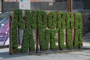 una valla cubierta de plantas que deletrean la palabra jardín en Hotel Starc by Pierre & Vacances Premium en Andorra la Vella