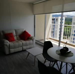 uma sala de estar com um sofá e uma mesa em Apartamento Puerto Azul- Ricaurte em Ricaurte