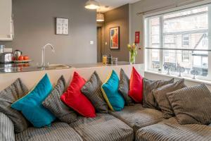 un sofá con almohadas coloridas en la cocina en The Exchange Apartments with Permit Parking, en Tewkesbury