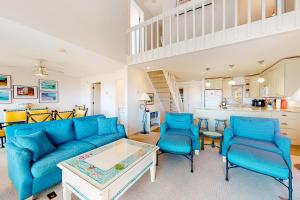 a living room with a blue couch and chairs at Great Lakes 49 50 in Glen Arbor