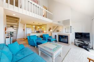 a living room with a blue couch and a fireplace at Great Lakes 49 50 in Glen Arbor