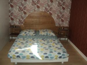 a bed with a wooden headboard in a room at mireille in Villedoux