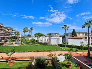 - une vue sur un parc avec des palmiers et des bâtiments dans l'établissement Apartment in Residence BaiaSole, à Sanremo