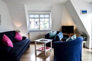 a living room with two couches and a table at Appartement Fördetraum am Strand von Wassersleben App 9 in Harrislee
