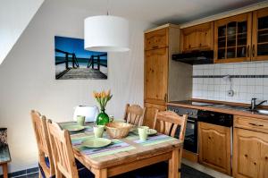 a kitchen with a table with chairs and a pier at Appartement Fördetraum am Strand von Wassersleben App 9 in Harrislee