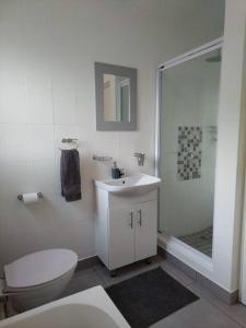 a white bathroom with a toilet and a shower at Breathtaking 3 Bedroom unit with amazing sea views in Ramsgate