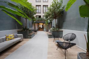 a courtyard with chairs and tables and plants at numa I Brio in Barcelona