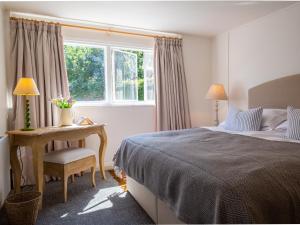 a bedroom with a bed and a desk and a window at Arrow Lodge at Ragley Estate 