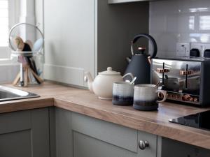 um balcão de cozinha com um bule de chá e chávenas em Arrow Lodge at Ragley Estate 