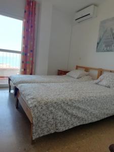 een slaapkamer met 2 bedden en een raam bij Magnifique vue à 100m de la plage in Benalmádena