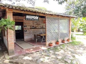 a building with a table and a sign on it at Finca Hostal Bolivar - Casa Quinta in Minca