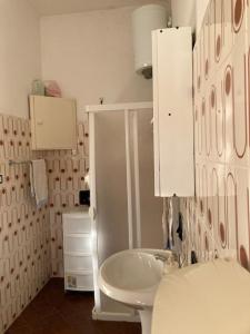 uma casa de banho com um lavatório branco e um WC. em Al Fresco Mare em Triscina