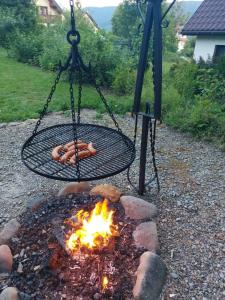a fire pit with a swing and a fire at Watra apartamenty z aneksami in Wetlina