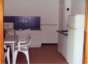 kuchnia ze stołem, krzesłami i lodówką w obiekcie Maison cosy avec vue sur la mer à Pietrosella, 60 m². w mieście Pietrosella