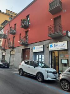 a white car parked in front of a building at n&ghomesweethome RaffaelloElegante appartamento ideale casa vacanze affari in Milan