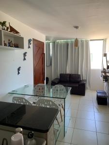 eine Küche und ein Wohnzimmer mit einem Tisch und Stühlen in der Unterkunft Maragogi Flat Residence in Maragogi