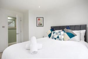 een slaapkamer met een groot wit bed met kussens bij Fabulous Modern Luxury Apartment Sleeps 6- Parking in Belfast