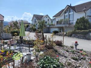 um jardim com um guarda-sol verde e algumas casas em B&B on Top em Sirnach