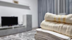 uma pilha de toalhas sentadas numa mesa numa sala de estar em Mega Apart in Almaty em Almaty
