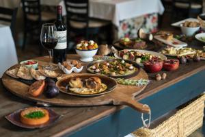 una mesa con platos de comida y una botella de vino en Angelats Hotel, en Ribes de Freser