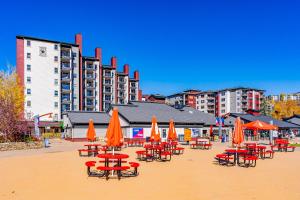 un grupo de mesas y sillas con sombrillas naranjas en Torian Plum Plaza 508, en Steamboat Springs 3 fotos más