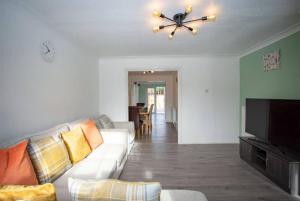 un soggiorno con divano e ventilatore a soffitto di Cozy 3-Bedroom Home in Luton a Luton