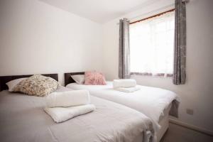 two beds sitting next to each other in a bedroom at Cozy 3-Bedroom Home in Luton in Luton