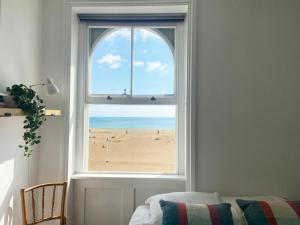 a window with a view of the beach at Spacious 2BD Flat with Stunning Views Folkestone in Folkestone