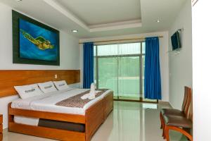 a bedroom with a bed and a large window at Hotel Galapagos Tortuga Bay in Puerto Ayora