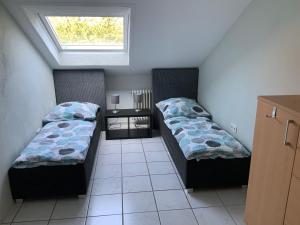 two beds in a small room with a window at Apartment und Ferienwohnung Mackenbach in Mackenbach